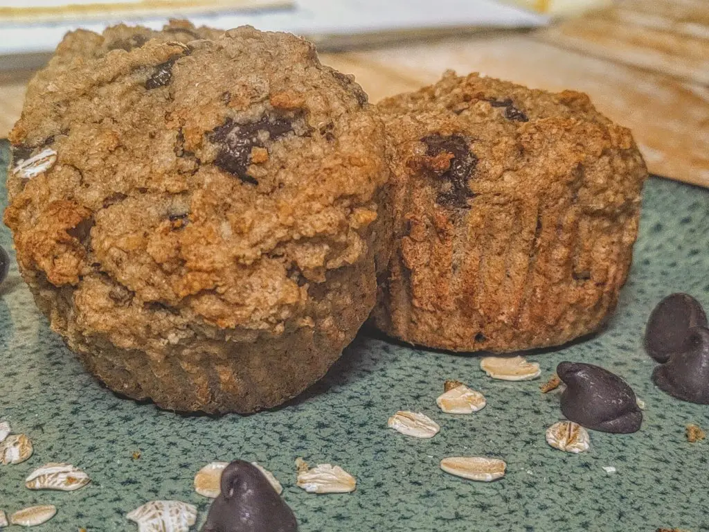 Two Easy Tahini Chocolate Chip Muffins sitting on a blue plate.