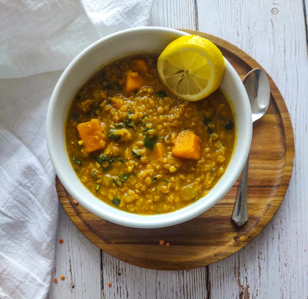 Red lentil soup in a white bowl.